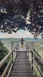 Rear view of woman on footbridge