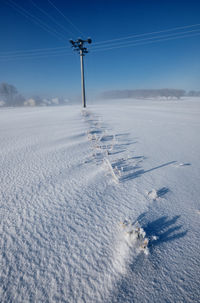 Scenic view of snow covered field against sky