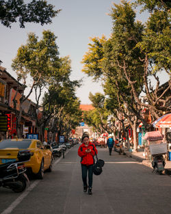 People on street in city against sky