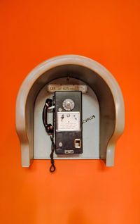 Close-up of telephone against orange background