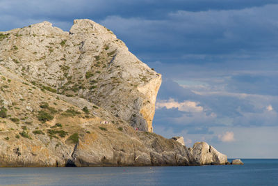 Rock formations by sea against sky