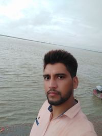 Portrait of young man against sea