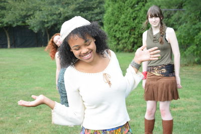 Happy friends standing on grassy field