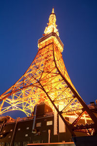 Low angle view of illuminated tower against blue sky