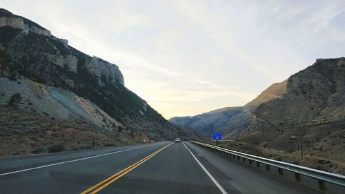 Road amidst mountains against sky