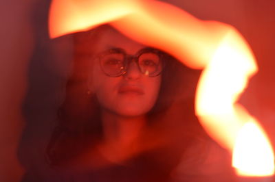 Close-up of woman with illuminated string lights