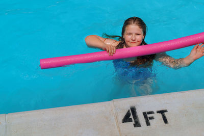 Portrait of happy girl in swimming pool