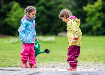 Side view of twin girls standing in park