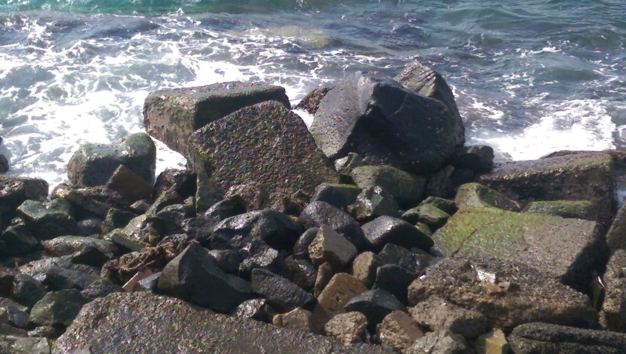 HIGH ANGLE VIEW OF ROCKS ON SHORE AT SEA