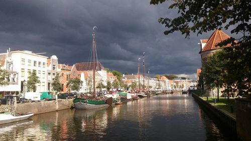 Buildings in city against cloudy sky