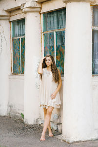 Portrait of a beautiful girl in a summer dress with long hair, who holds her hand in her hair