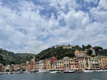 Scenic view of sea by townscape against sky