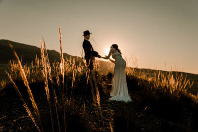 Couple in a field at sunset among dry plants. wedding concept