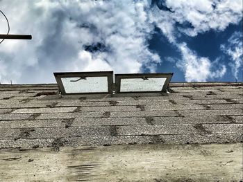 Low angle view of empty bench against sky