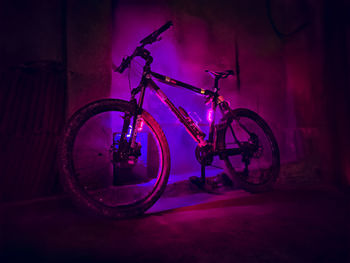 Side view of bicycle against illuminated wall