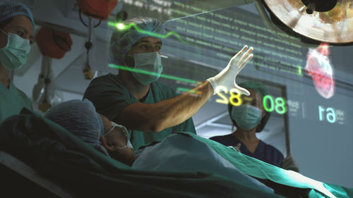 A surgeon diagnose a woman's heart problem via a holographic body scan before surgical procedure