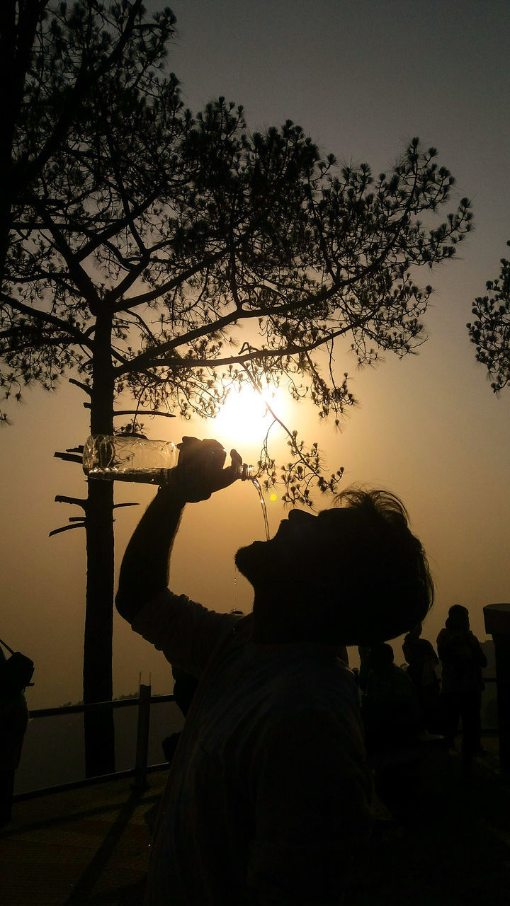 SILHOUETTE MAN USING SMART PHONE AGAINST SKY