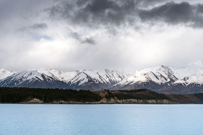 Gloomy landscape of new zealand southern alps and lake pukaki with blue sky and clouds.