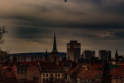 Buildings in city against sky at sunset