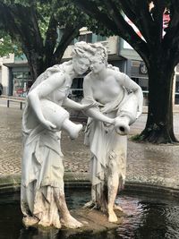 Statue against trees and plants in park