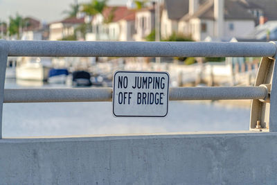 Close-up of information sign on railing