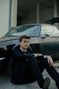 Young man looking away while sitting in car