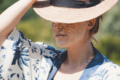 Close-up of woman wearing hat during sunny day