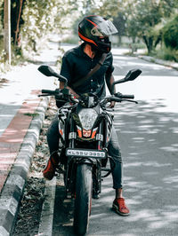 Rear view of man riding bicycle on road