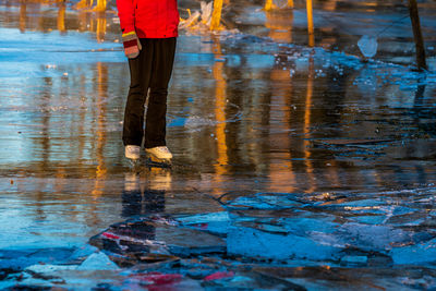 Low section of man on wet road during rainy season