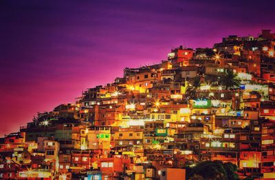 Illuminated cityscape against clear sky at night