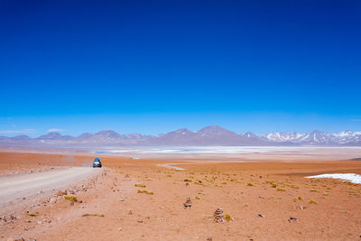 Scenic view of desert against clear blue sky