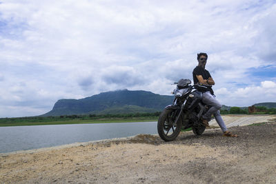 Man riding motorcycle on mountain against sky