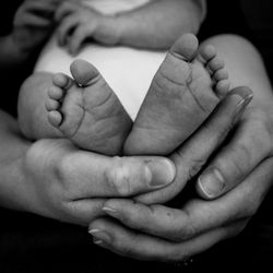 Lo section of woman holding child against black background