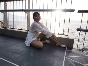 Portrait of a smiling young woman sitting on floor