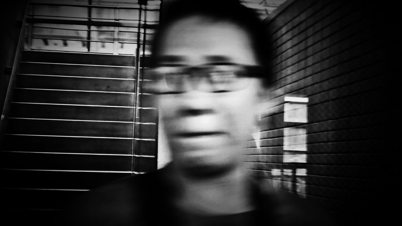 one person, headshot, real people, portrait, lifestyles, leisure activity, blurred motion, indoors, front view, young adult, selective focus, window, human body part, men, young men, motion, blinds, sunlight, contemplation, human face