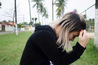 Side view of young woman on field