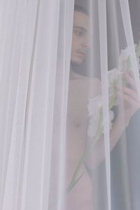 Portrait of woman standing by window