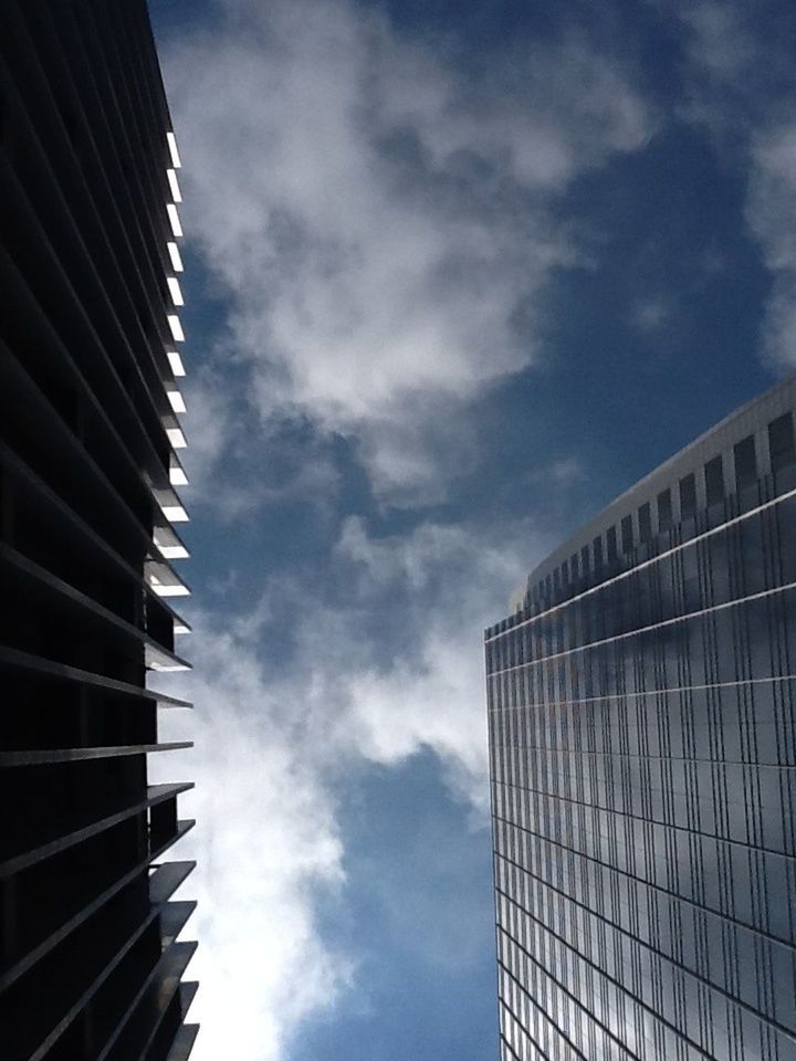 low angle view, architecture, built structure, building exterior, sky, modern, office building, cloud - sky, skyscraper, tall - high, city, building, tower, cloud, cloudy, glass - material, day, outdoors, no people, reflection