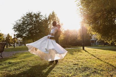 Woman on field by trees against sky