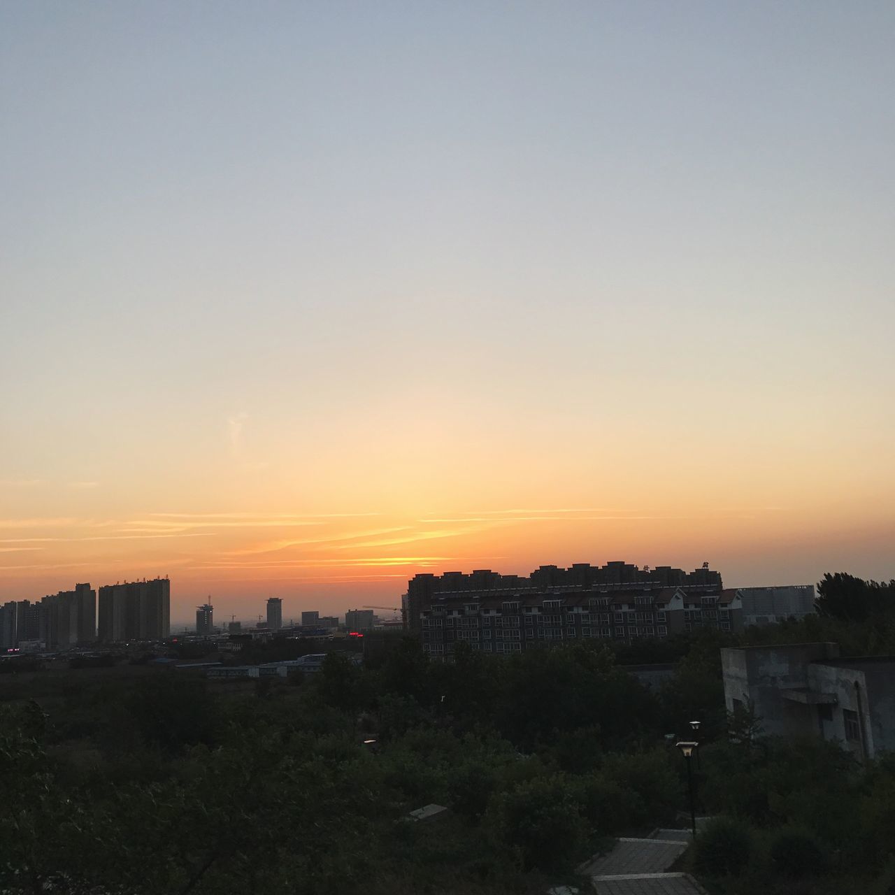 sunset, architecture, orange color, building exterior, built structure, cityscape, no people, city, travel destinations, outdoors, sky, tree, nature, skyscraper, clear sky, beauty in nature, day