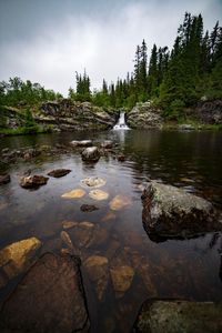 Scenic view of rocks in lake against sky