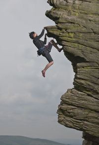 Woman climbing at windgather rocks in the british peak district
