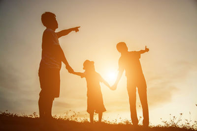 Silhouette people against sky during sunset