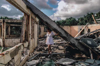 Woman standing by built structure against sky