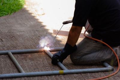 Rear view of man working on metal