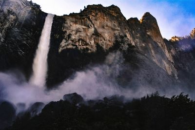 Low angle view of waterfall against sky