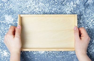 Midsection of woman holding paper against wall