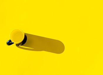 Low angle view of electric lamp against yellow background