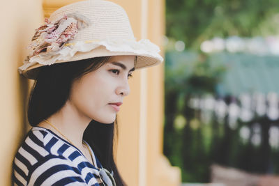 Young woman wearing hat standing outdoors