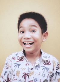 Portrait of smiling boy against yellow wall